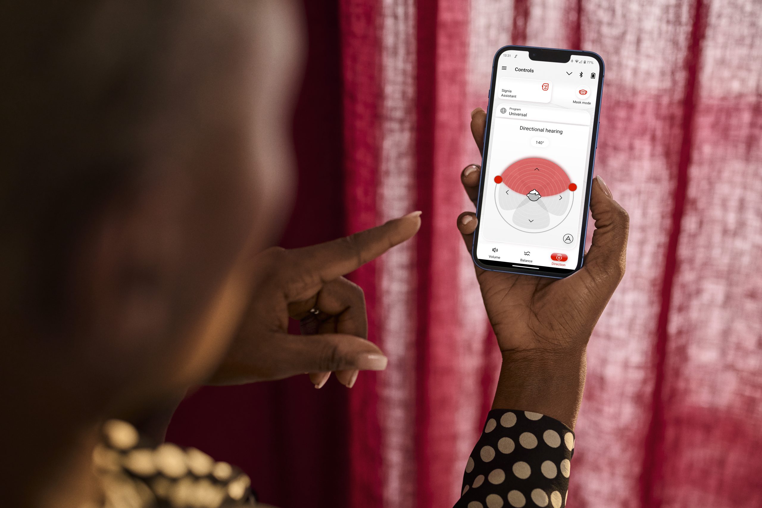 Woman using a smartphone device app to control her hearing aid settings.